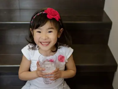 Child smiling with glass of water