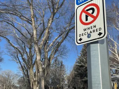 snow route no parking sign on street lamppost winter