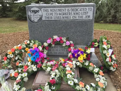 CUPE memorial headstone with flower wreaths