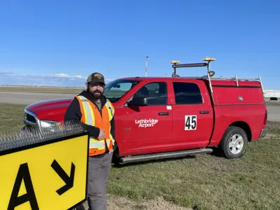 Anthony Kish Lethbridge on runway with Airport fleet vehicle 