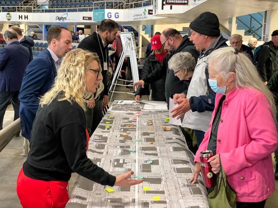 People talking over a table with a map showing  City transportation projects